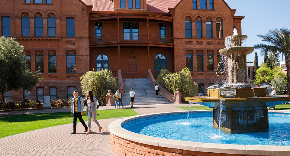 Students walk in front of the Old Main building on ASU campus
